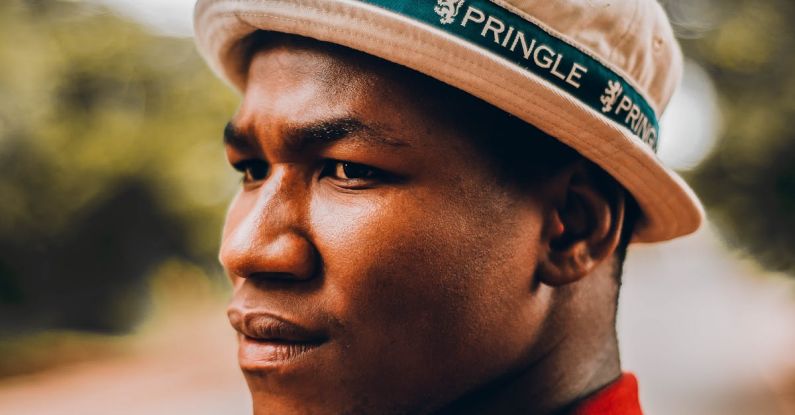 Decision Trees - Side view of serious frowning African American male standing on street with blurred green trees