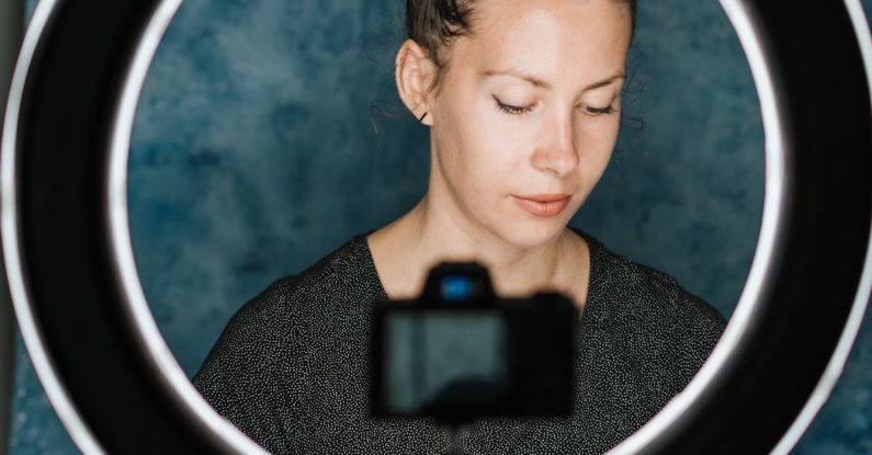 Scenario Planning - Young female examining notes in notebook in professional studio with photo camera and studio lamp