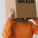 Capacity Planning - Crop person putting Idea title in cardboard box with Brain inscription on head of female on light background