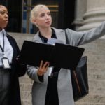 Risk Management Plan - Low angle of diverse elegant women with identity badges working in government office and discussing building in town