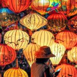 Culture - Two Person Standing Near Assorted-color Paper Lanterns