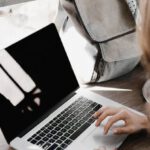 Project Casebook - Close-up Photography of Woman Sitting Beside Table While Using Macbook