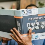 Business Fundamentals - Person Reading a Book About Fundamentals of Financial Planning