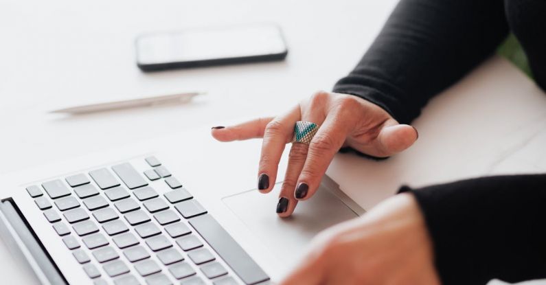 SWOT Analyses - Crop female using touchpad on laptop in office